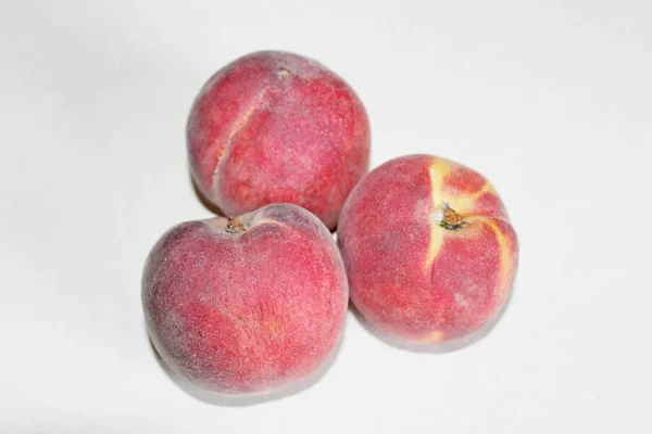 Pêches allongées sur la table sur un fond blanc — Photo