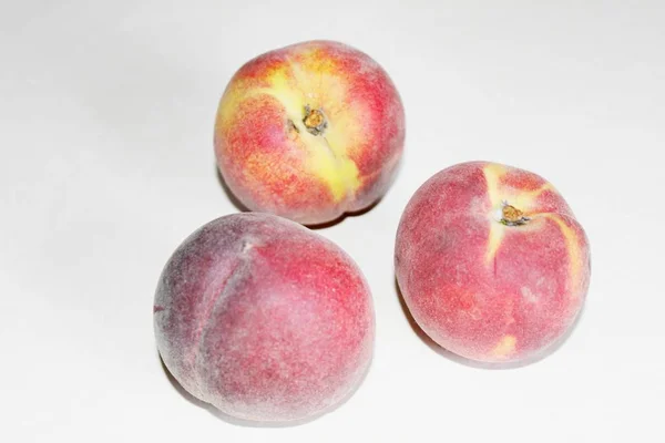 Pêches allongées sur la table sur un fond blanc — Photo