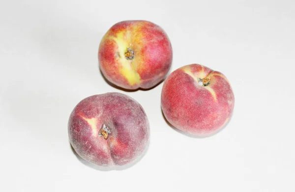 Pêches allongées sur la table sur un fond blanc — Photo