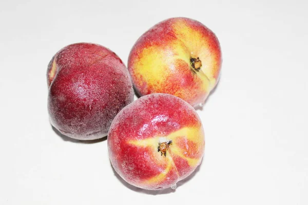 Pêches allongées sur la table sur un fond blanc — Photo