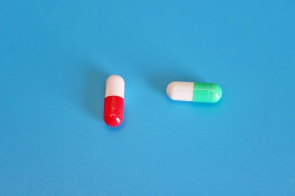 Фармакологические таблетки на синем фоне — стоковое фото