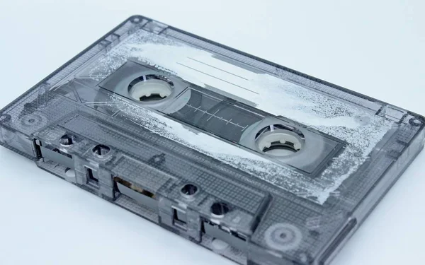 Old audio cassette located on a white background