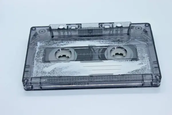Old audio cassette located on a white background