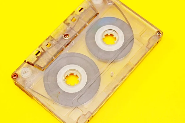 Sarı arka plan üzerinde bulunan eski saydam ses kaseti — Stok fotoğraf