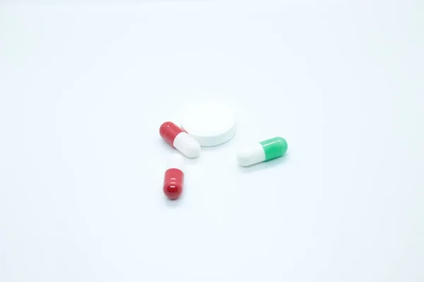 Многоцветные таблетки капсулы расположены на белом фоне — стоковое фото