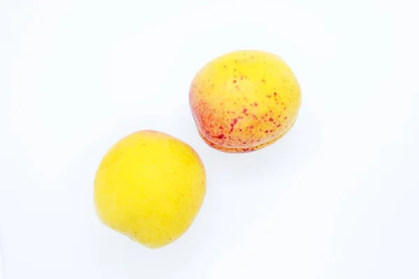 Смачні соковиті абрикоси розташовані на білому тлі — стокове фото