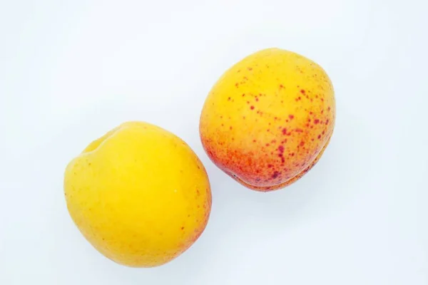 Delicious juicy apricots are located on a white background — Stock Photo, Image