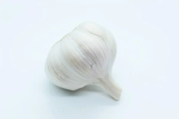 A cabeça de alho está localizada em um fundo branco — Fotografia de Stock