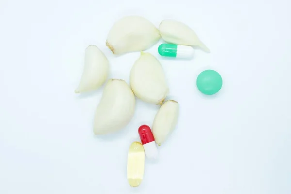 Teentjes knoflook pillen capsules gelegen op een witte achtergrond — Stockfoto