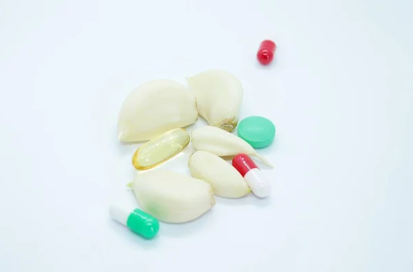 Alho descascado e vitaminas localizadas em um fundo branco — Fotografia de Stock