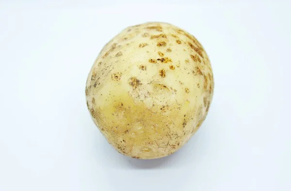 Patatas crudas sin pelar situadas sobre un fondo blanco —  Fotos de Stock