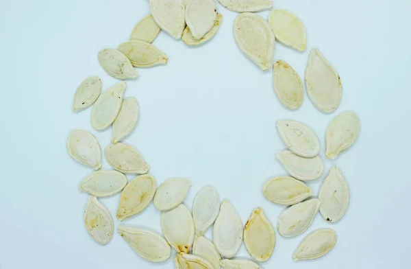 Beyaz arkaplanda bulunan beyaz kabak tohumları — Stok fotoğraf