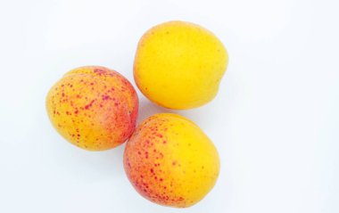 Beyaz arka planda olgun, sulu kayısılar.