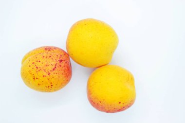 Beyaz arka planda olgun, sulu kayısılar.