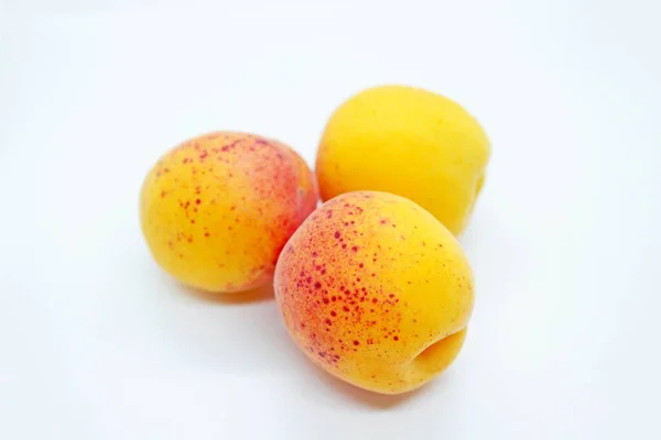 Стиглі смачні соковиті абрикоси, розташовані на білому тлі — стокове фото