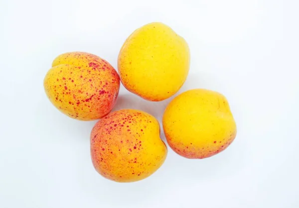 Спелые вкусные сочные абрикосы, расположенные на белом фоне — стоковое фото