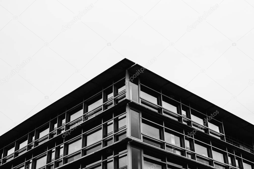 Close view of modern futuristic building against grey sky 