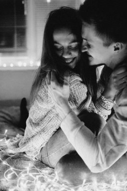 Sevgi dolu çift her diğer yatak odasında çelenk içinde kaydırma yatakta sarıl. Siyah ve beyaz fotoğraf gürültü filtresi ile