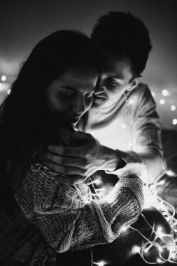 Sevgi dolu çift her diğer yatak odasında çelenk içinde kaydırma yatakta sarıl. Siyah ve beyaz fotoğraf gürültü filtresi ile