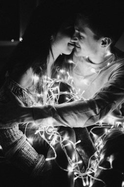 Sevgi dolu çift her diğer yatak odasında çelenk içinde kaydırma yatakta sarıl. Siyah ve beyaz fotoğraf gürültü filtresi ile