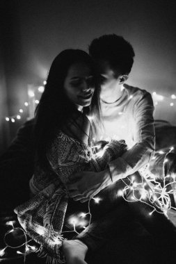 Sevgi dolu çift her diğer yatak odasında çelenk içinde kaydırma yatakta sarıl. Siyah ve beyaz fotoğraf gürültü filtresi ile