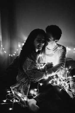 Sevgi dolu çift her diğer yatak odasında çelenk içinde kaydırma yatakta sarıl. Siyah ve beyaz fotoğraf gürültü filtresi ile