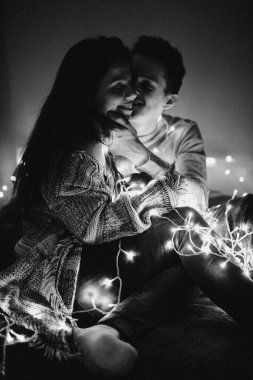 Sevgi dolu çift her diğer yatak odasında çelenk içinde kaydırma yatakta sarıl. Siyah ve beyaz fotoğraf gürültü filtresi ile