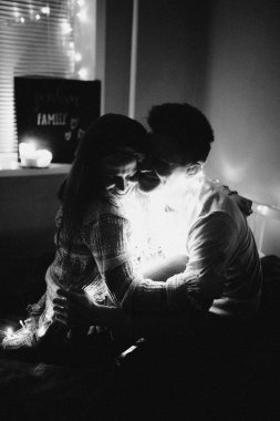 Sevgi dolu çift her diğer yatak odasında çelenk içinde kaydırma yatakta sarıl. Siyah ve beyaz fotoğraf gürültü filtresi ile