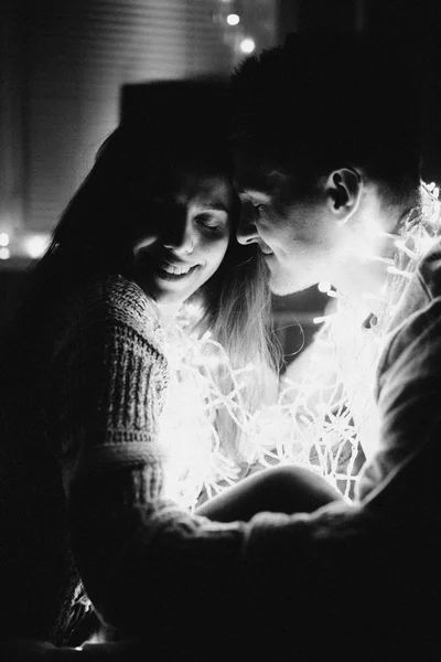 相爱的情侣在卧室的花环上互相拥抱 黑白照片 带噪音过滤器 — 图库照片