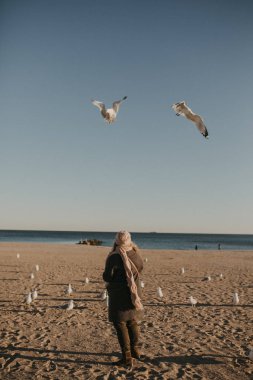 kız sahilde kuşlara