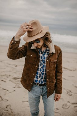 Genç adam portre havadar rüzgar zevk kumsalda uzun saçlı sakallı