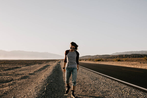 Handsome young man walking in the desert