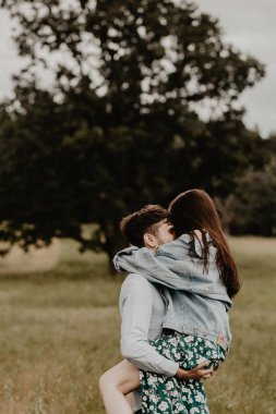 Yürüyüş ve yeşil alanına sarılma aşık genç çift portresi