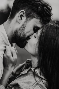 Yürüyüş ve çayırda sarılma aşık genç bir çift. Siyah ve beyaz fotoğraf.