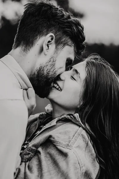 Yürüyüş ve çayırda sarılma aşık genç bir çift. Siyah ve beyaz fotoğraf.