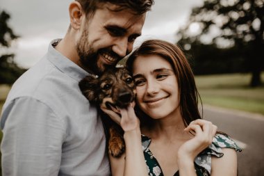 Köpek yeşil alanda ile sarılma aşık genç çift portresi