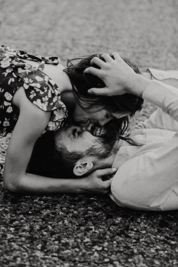 Yürüyüş ve çayırda sarılma aşık genç bir çift. Siyah ve beyaz fotoğraf.