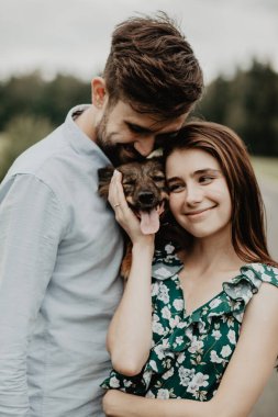 Köpek yeşil alanda ile sarılma aşık genç çift portresi