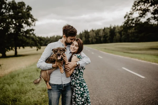 Köpek yeşil alanda ile sarılma aşık genç çift portresi