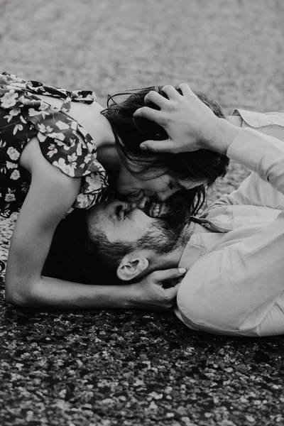 Yürüyüş ve çayırda sarılma aşık genç bir çift. Siyah ve beyaz fotoğraf.