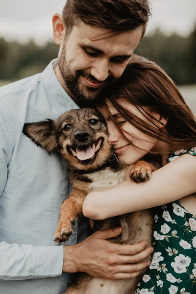 Retrato Pareja Joven Enamorada Abrazándose Con Perro Campo Verde —  Fotos de Stock