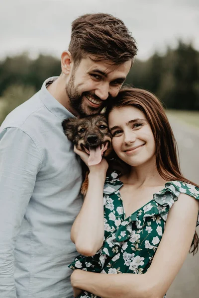 Retrato Pareja Joven Enamorada Abrazándose Con Perro Campo Verde —  Fotos de Stock