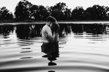 Genç çift göle, siyah ve beyaz sarılma