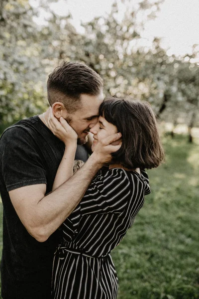 Porträtt av lyckligt leende par i kärlek njuta av varandra i blommande trädgård — Stockfoto