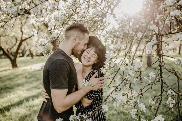 Портрет щасливої усміхненої пари закоханих насолоджуйтесь один одним у квітковому саду — стокове фото