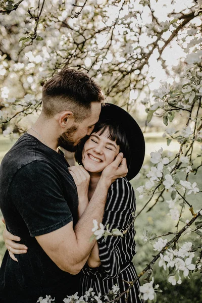 Retrato de feliz pareja sonriente enamorada disfrutar el uno del otro en el jardín floreciente —  Fotos de Stock