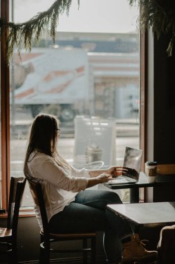 Genç kız öğrenci on-line önünde açık net-kitap oturan akıllı kadın onun ders önce dizüstü bilgisayar üzerinden öğrenme akıllı