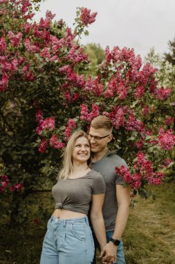 Çiçekli bahar bahçesinde aşık mutlu bir çift.
