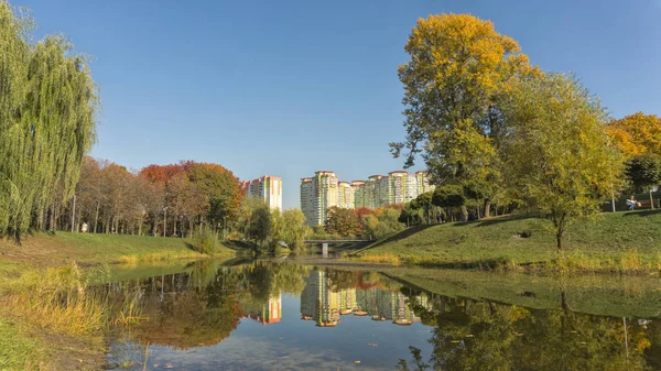 美丽的秋天的颜色反射出一个池塘 秋天公园与高大厦 — 图库照片