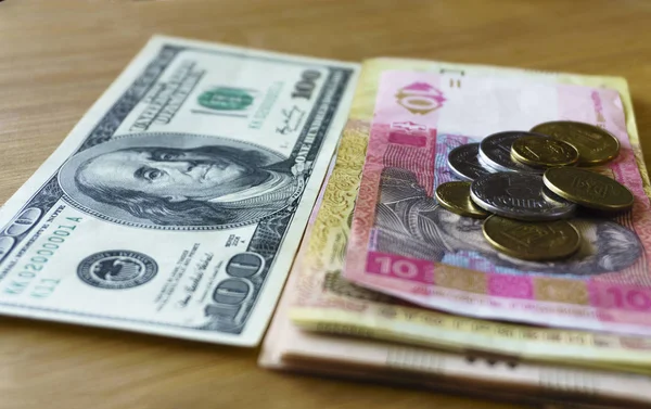 Moedas de metal ucraniano de 1, 2 hryvnias empilhadas contra 100 dólares americanos, redução das hryvnias e o dólar de perto. moeda — Fotografia de Stock